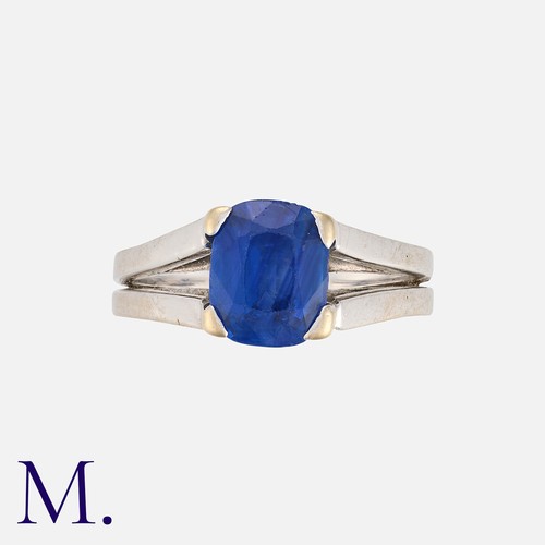 123 - A Sapphire Ring in 18 carat white gold, the bifurcated band set with a cushion cut sapphire of appro... 