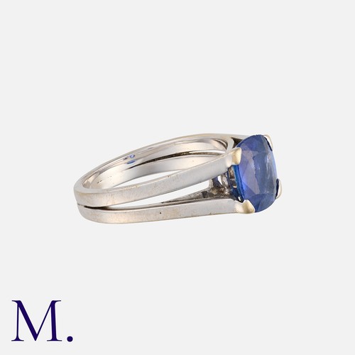 123 - A Sapphire Ring in 18 carat white gold, the bifurcated band set with a cushion cut sapphire of appro... 