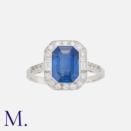 158 - A Sapphire and Diamond Cluster Ring in 18K white gold, set with a rich blue octagonal cut sapphire w... 