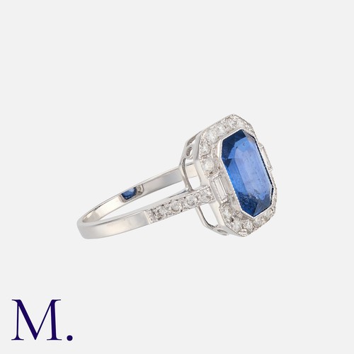 158 - A Sapphire and Diamond Cluster Ring in 18K white gold, set with a rich blue octagonal cut sapphire w... 