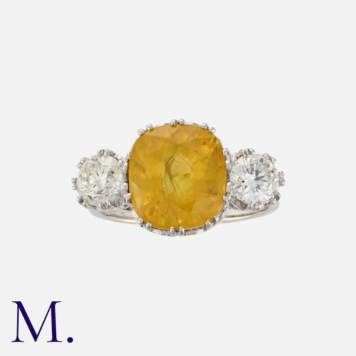 138 - A Yellow Sapphire and Diamond Ring in white gold, set to the centre with a strong yellow sapphire we... 
