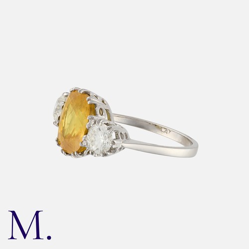 138 - A Yellow Sapphire and Diamond Ring in white gold, set to the centre with a strong yellow sapphire we... 