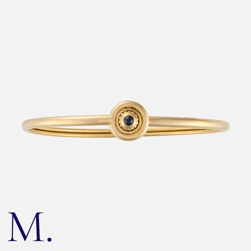 125 - CARTIER. A Sapphire Bangle in 18K yellow gold, set with a cabochon sapphire. Signed Cartier, serial ... 