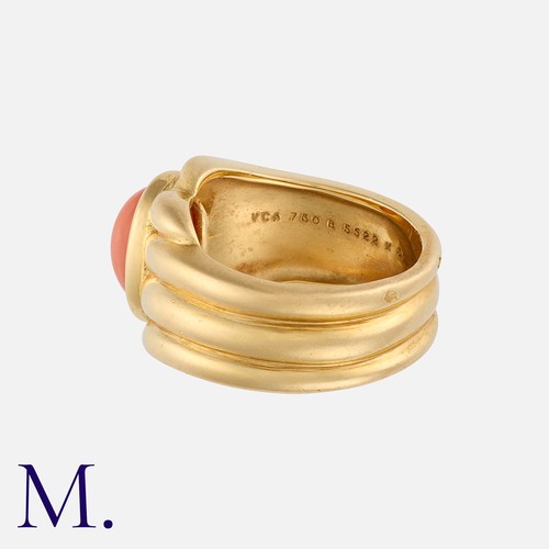 130 - VAN CLEEF & ARPELS. A Coral Ring in 18K yellow gold, set with a cabochon onyx to the centre with flu... 