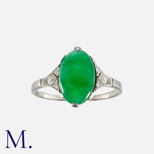 101 - An Art Deco Jade Ring in platinum, set with an oval cabochon of jade with diamond accents either sid... 
