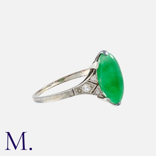 101 - An Art Deco Jade Ring in platinum, set with an oval cabochon of jade with diamond accents either sid... 