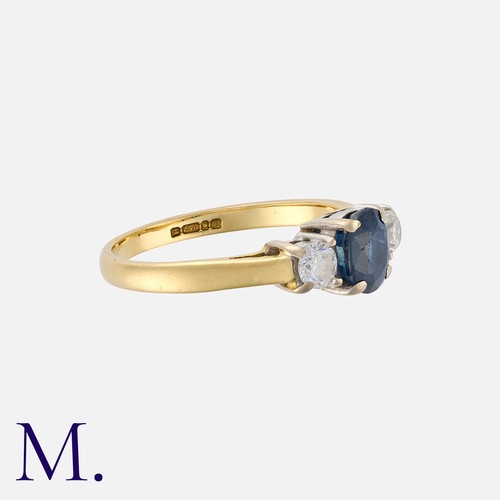 89 - A Sapphire and Diamond Three Stone Ring in 18 carat yellow gold, comprising a central oval cut blue ... 