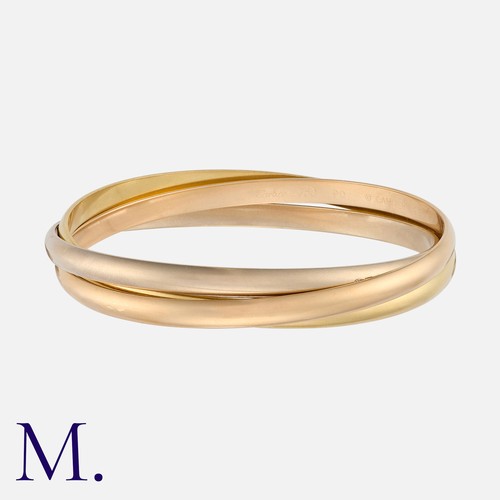 78 - CARTIER. A Trinity Bangle in 18K yellow, white and rose gold (4mm wide).  Signed Cartier 1997 and se... 