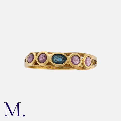 55 - A Ruby and Sapphire Ring in 18 carat yellow gold, set with a central oval cut sapphire, flanked eith... 