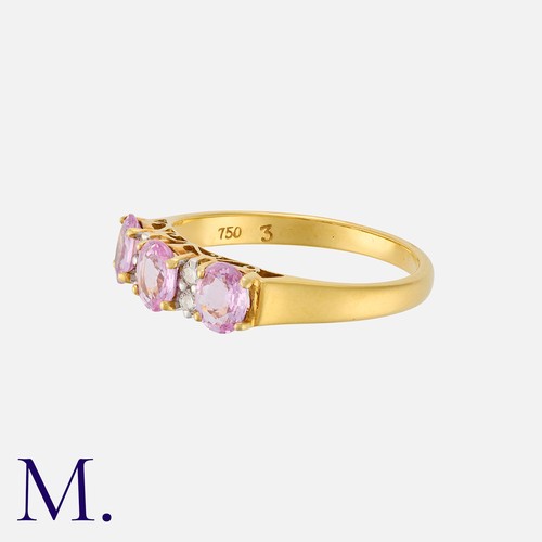 16 - A Pink Sapphire and Diamond Ring in 18 carat yellow gold, set with three oval cut pink sapphires, pu... 