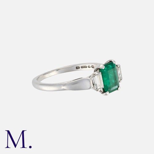 32 - An Emerald and Diamond Ring, in 18 carat gold, set with a central step cut emerald of approximately ... 