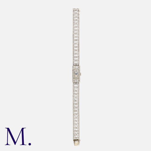 57 - An Diamond Cocktail Watch in platinum, the dial with Arabic numeral indices, minute track and blued ... 