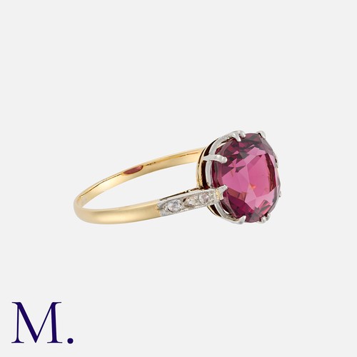 10 - A Rhodolite Garnet and Diamond Ring in yellow gold, set with a cushion shaped rhodolite garnet of ap... 