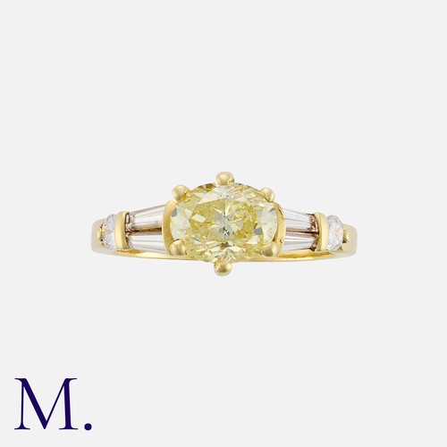 152 - A 1.00 Carat Fancy Yellow Diamond Ring in 18 carat yellow gold, set with a principal oval cut fancy ... 