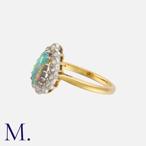 3 - An Opal and Diamond Cluster Ring in 18 carat yellow gold, set with a pear shaped cabochon opal withi... 