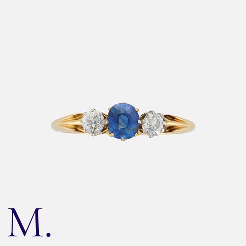 137 - A Sapphire and Diamond Three Stone Ring in 18 carat yellow gold. Set with a principal cushion cut sa... 