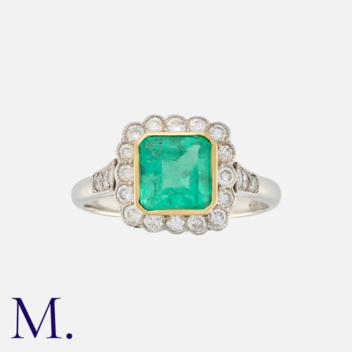 138 - An Emerald and Diamond Ring in platinum and yellow gold, set with a rectangular cut emerald weighing... 