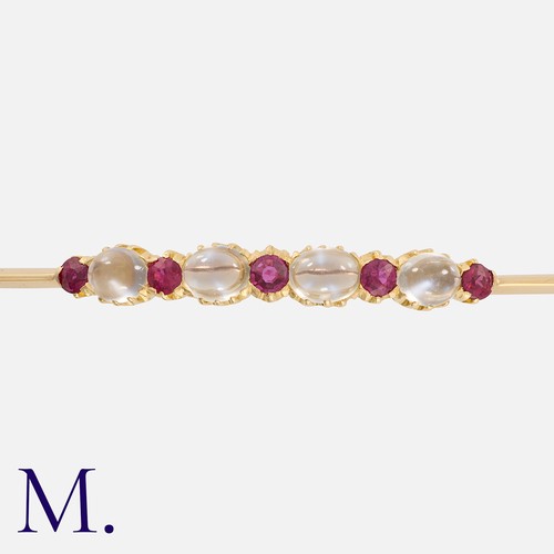 167 - A Moonstone and Ruby Brooch in yellow gold, set with an alternating row of round cut rubies and cabo... 