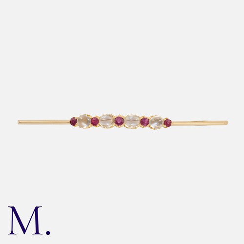 167 - A Moonstone and Ruby Brooch in yellow gold, set with an alternating row of round cut rubies and cabo... 