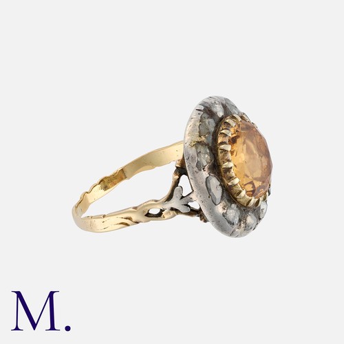 116 - A Georgian Topaz and Diamond Ring in yellow gold and silver, the round-cut topaz in a closed-back cu... 