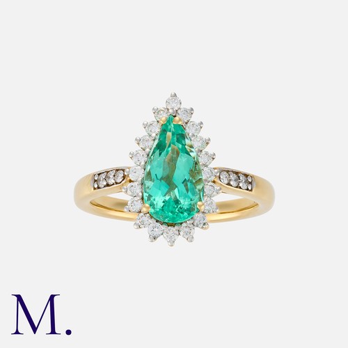 62 - An Emerald and Diamond Cluster Ring in 18K yellow gold, set with a pear-cut emerald weighing approx.... 