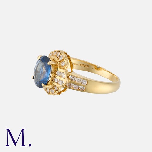 87 - A Sapphire and Diamond Cluster Ring in 18K yellow gold, set with an oval cut sapphire weighing appro... 