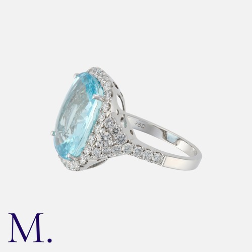 118 - An Aquamarine and Diamond Cluster Ring in 18 carat white gold, set with a principal aquamarine of ap... 