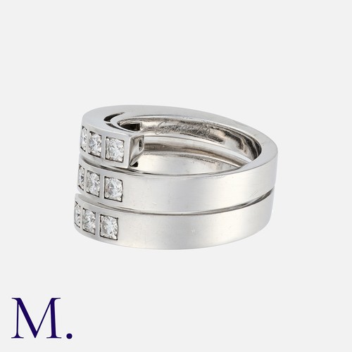 112 - CARTIER, A Diamond Ring in 18 carat white gold, comprising a single coiled bad set with nine round b... 