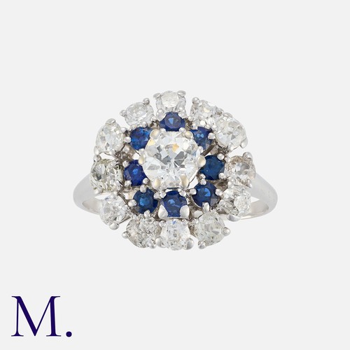 74 - CHAUMET. A Sapphire and Diamond Cluster Ring in platinum, set with an old cut diamond to the centre ... 