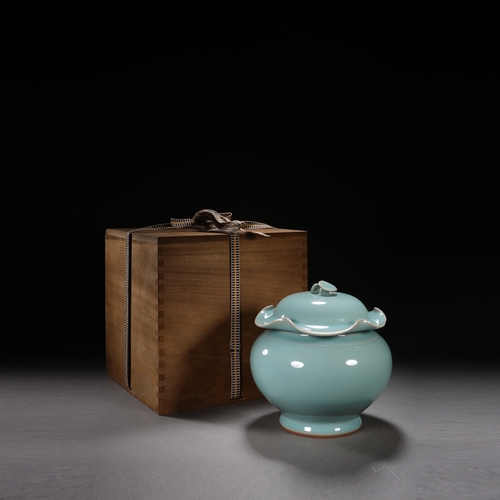 202 - A celadon glaced 'lotus' jar and cover 18cm high, 17cm wide