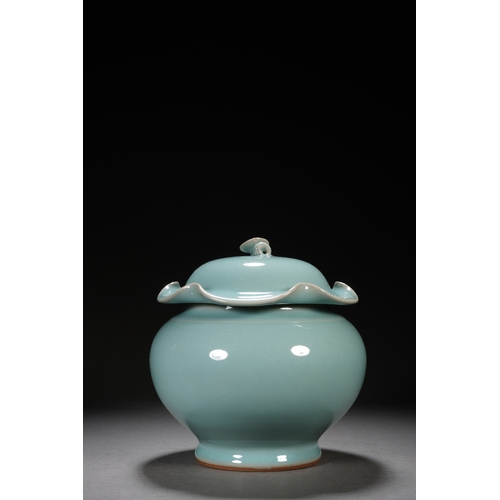 202 - A celadon glaced 'lotus' jar and cover 18cm high, 17cm wide