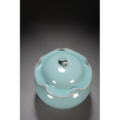 202 - A celadon glaced 'lotus' jar and cover 18cm high, 17cm wide