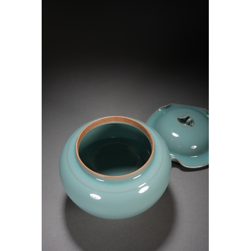 202 - A celadon glaced 'lotus' jar and cover 18cm high, 17cm wide