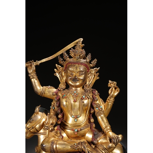 82 - A gilt bronze seated status of the four-armed Dharma King, Qing Dynasty 24.5cm high, 21cm wide... 