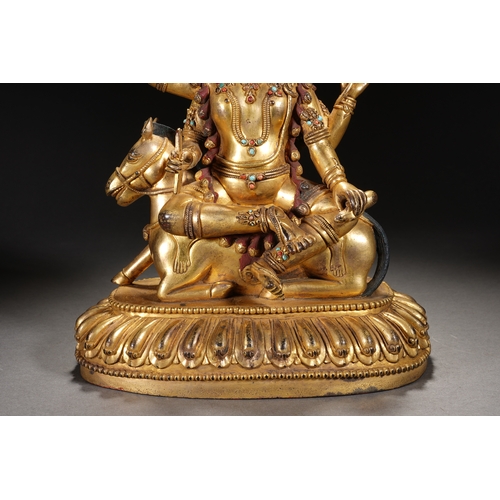 82 - A gilt bronze seated status of the four-armed Dharma King, Qing Dynasty 24.5cm high, 21cm wide... 