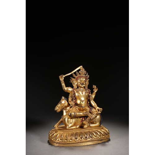 82 - A gilt bronze seated status of the four-armed Dharma King, Qing Dynasty 24.5cm high, 21cm wide... 