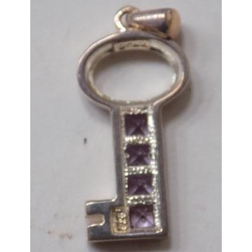 128 - Silver key pendant with 4 purple stones