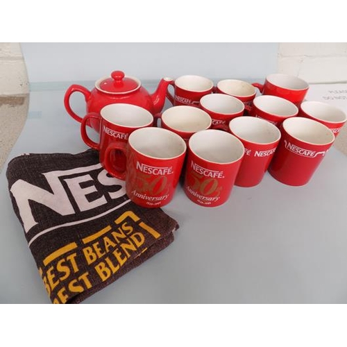 8 - 11 Nescafe mugs, 1 Kit Kat mug, 1 Red teapot and 1 Nescafe tea towel