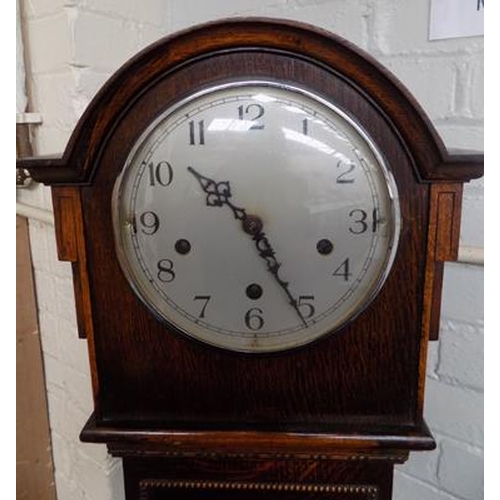 91 - Wooden cased granddaughter clock with key + pendulum