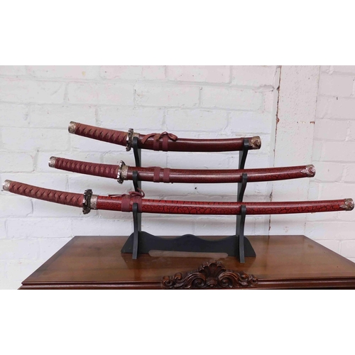 538a - 3x Samurai swords on display stand...