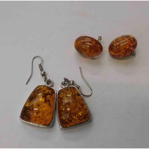 266 - Two - pairs of amber earrings - white metal & silver - one pair clip on & one pair drop