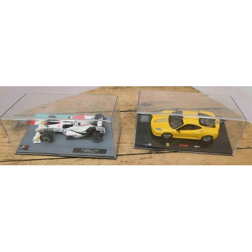 19 - Two - die cast cars in display cases - Brown GP1-2009 Jenson Button & 430 Ferrari...