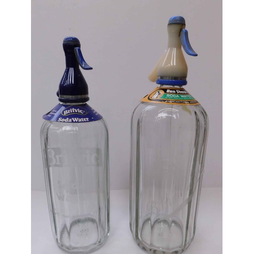 66 - Two - glass soda syphons...