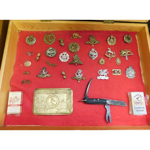 116 - Mixed militaria collection including - WWI & WWII era cap badges - WWI tin & knife in display case