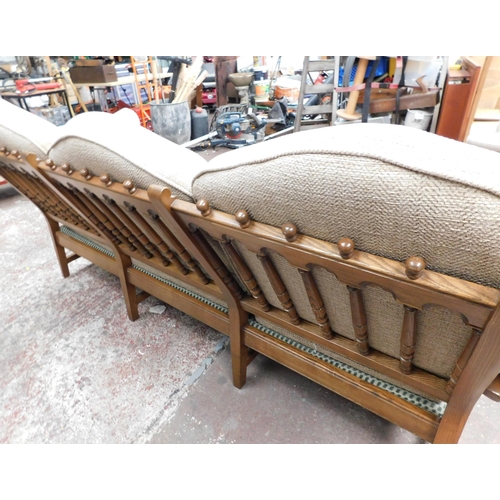 559A - Three seater Ercol settee (slight damage to one arm)