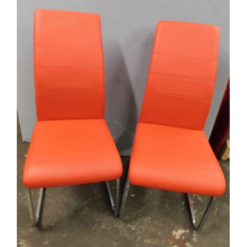 557 - Two red faux leather dining chairs