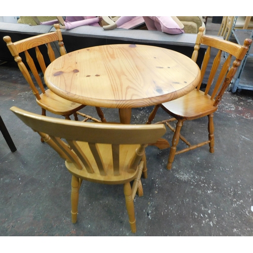 566 - Pine circular dining table and three chairs