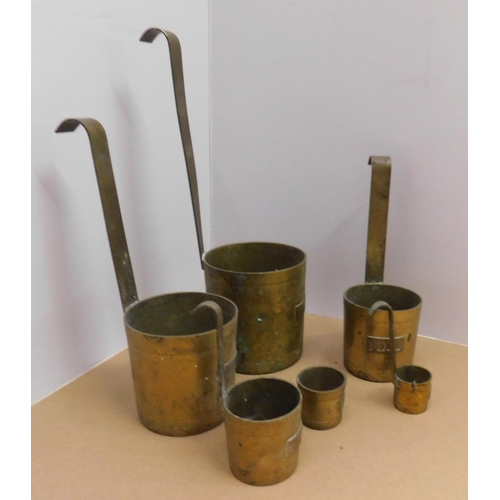 677 - Six brass liquid measures - one handle missing