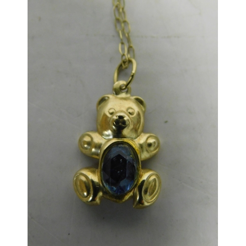 498 - 9ct Gold chain with teddy bear pendant set - with a blue topaz, weight 0.7g