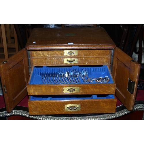 165 - Oak table part canteen of cutlery having double doors concealing four drawers with brass fittings, 5... 